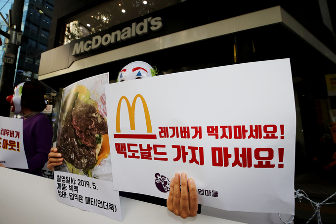  '정치하는엄마들' 회원들이 29일 오전 서울 중구 맥도날드 서울시청점 앞에서 '한국맥도날드 불매, 퇴출 기자회견'을 열고 덜 익은 햄버거 패티, 불량제품 등에 대한 검찰 수사 촉구 손팻말을 들고 있다.