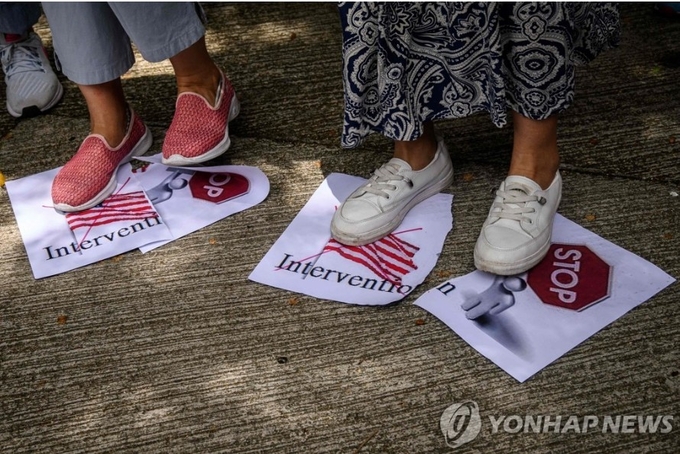 미국 상원의 홍콩자치법 가결에 항의하는 친중시위대들이 홍콩의 미국 총영사관 앞에서, 홍콩에 대한 미국의 간섭를 중단하라는 유인물을 뿌리며 시위하는 장면 AFP=연합뉴스 / 한중21 제휴사