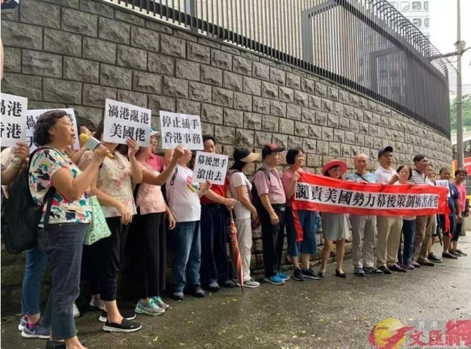 2019년 8월 , 홍콩시민단체가 미국영사관앞에서 ' 홍콩의 혼란을 부추기는 미 영사관은 돌아가라' 는 등의 구호를 외치며 시위하고 있다. 원회왕, 환치우르빠오 캡쳐.