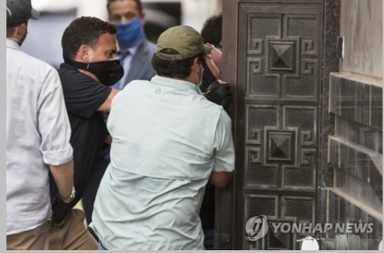 마침내 도구를 이용해 문을 부순 미국정부관리들이, 급한 듯 앞다투어 들어가는 모습이다. 연합뉴스/한중 21 제휴사.