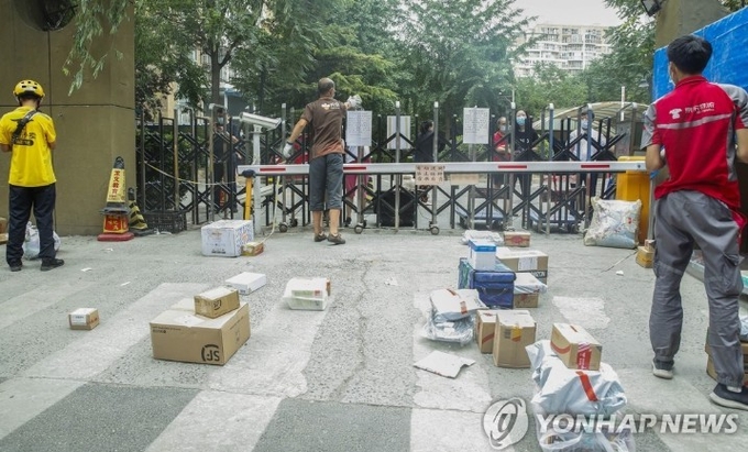 <strong>지난 7월 신파디시장에서 퍼진 베이징의 코로나19 2차 역습때 베이징의 아파트단지들이 외부와 격리되자, 주택단지 앞에서 택배 물품들을 전해주는 택배맨들이 급중했다.</strong> 신화=연합뉴스/ 한중 21 제휴사