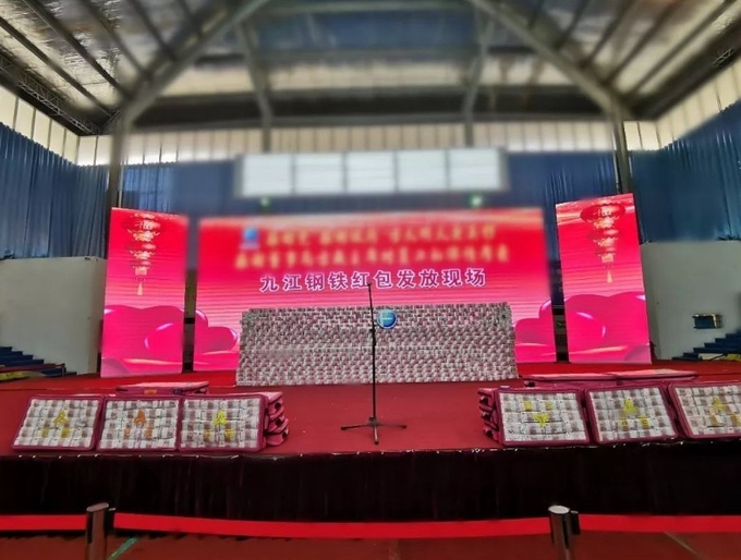 지우지앙제철회사( 江西方大九钢)가 매년 춘절, 음력설에 현금보너스를 선물하기 위한 행사의 무대위에 벽돌처럼 위안화현금다발을 쌓아서 현금제단을 만들어 놓은 모습. 인민왕/펑황왕 캡쳐.