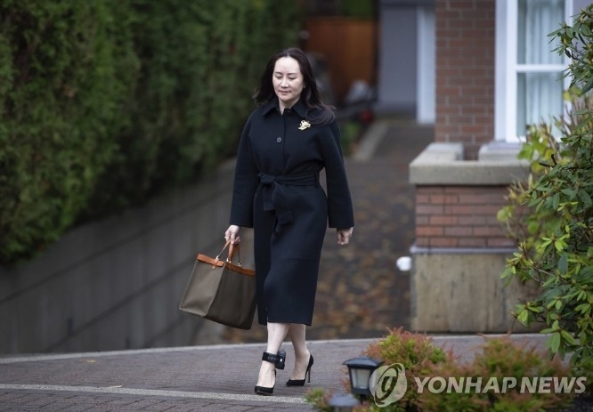 지난 2018년 12월 1일, 미중간의 무역전쟁와중에 캐나다경찰에 체포돤 화웨이의 CFO 멍완저우 ( 孟晚舟), 자택연급중 재판정에 출두하기 위해 나오고 있는 모습. 왼쪽 발목에 전자팔찌를 차고 있다. 연합뉴스(제휴사)