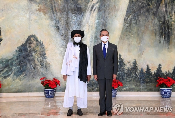 7월 28일 톈진에서 탈레반 2인자 물라 압둘 가니 바라다르와 만난 왕이 중국 외교부장. 사진=연합뉴스/한중21 제휴사
