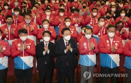 10일 새벽 당선을 예고하는 역전이 이뤄지자 윤석열(가운데) 대통령 당선자와 국민의 힘 당직자들이 박수를 치고 환호하고 있다. 연합/한중21제휴사 