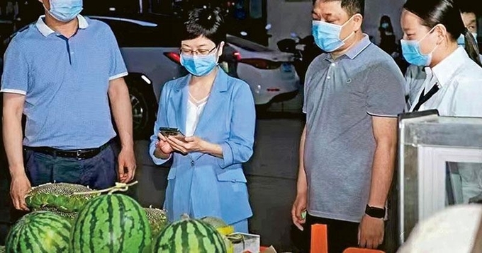 중국 허난성 관리들이 야시장에서 과일을 사고 있다. 사진=연합뉴스/한중21 제휴사