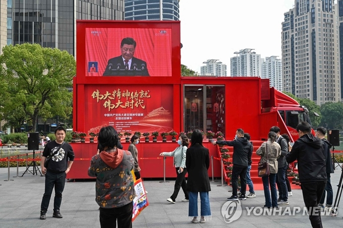 10월 16일 제20차 중국 공산당 전국대표대회 개막식 실황을 지켜보는 상하이 시민들. 사진=연합뉴스/한중21 제휴사 