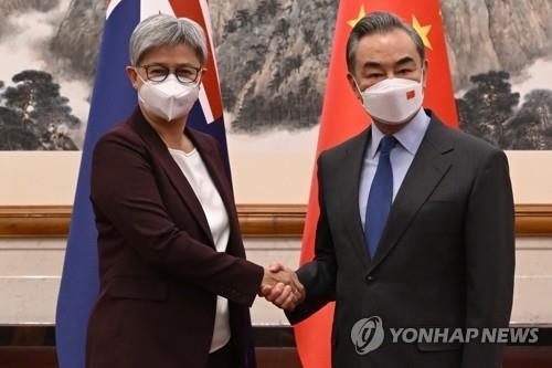 양국 수교 50주년을 기념해 중국을 방문한 페니 웡 호주 외교장관(왼쪽)이 12월 21일 베이징에서 왕이 중국 외교부장과 악수하고 있다. 사진=연합뉴스/한중21 제휴사